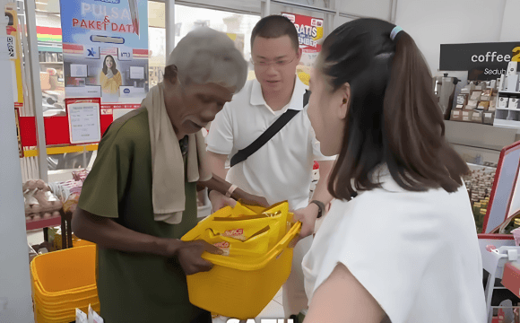 Jestham dan tim dengan penuh kehangatan membantu Bapak Bazarudin mengangkat keranjang belanja berisi minyak goreng dan kebutuhan pokok lainnya di minimarket.
