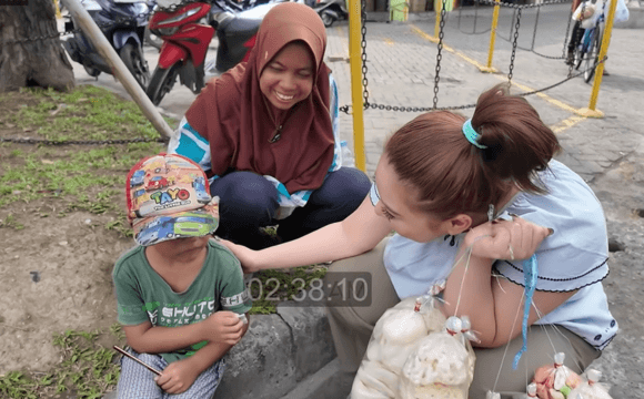A heartwarming moment as Jestham sat beside the fried cracker seller's child and shared happiness together.
