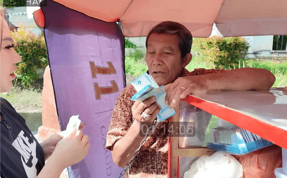 Bapak penjual keliling tampak terpaku memegang lembaran uang saat Jestham memborong seluruh dagangannya.